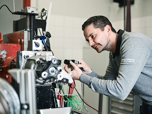 Person working on a machine in a manufacturing facility