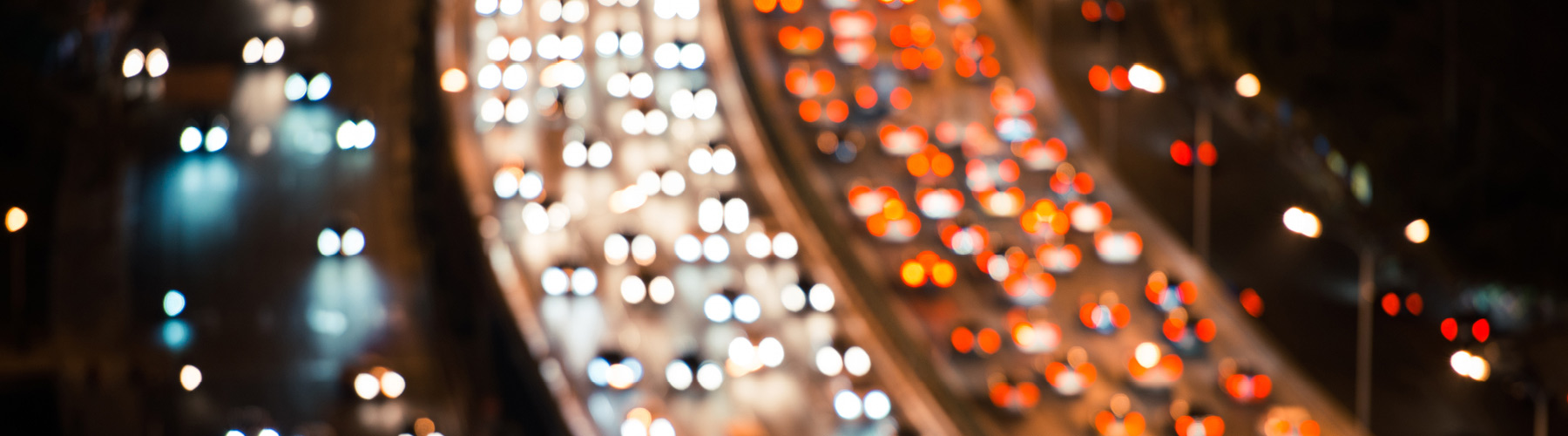 Head lights and tail lights of vehicles travelling along a highway.