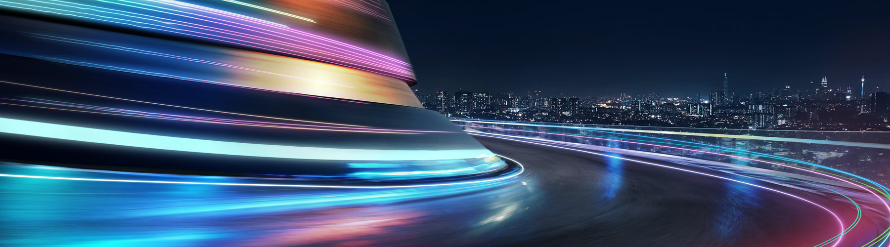 Wind road at night with blurred striking blue, orange, purple and pink lights