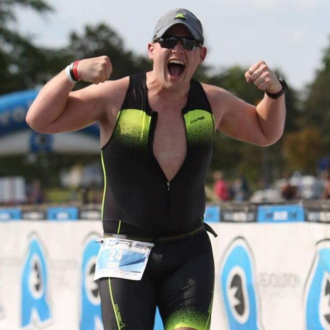Triathlet Luke Laidlaw feiert am Ziel mit erhobenen Armen